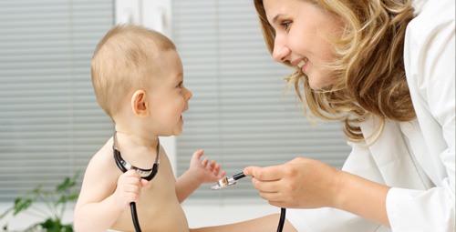 A female doctor showing her stethoscope to a baby